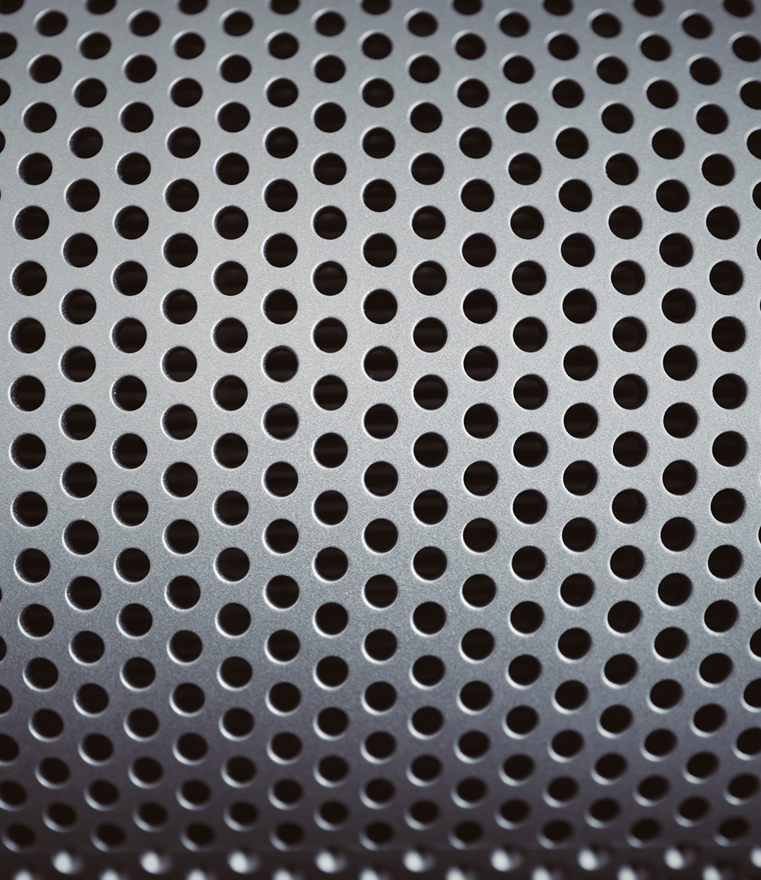 Close up image of drill holes in a metal sheet