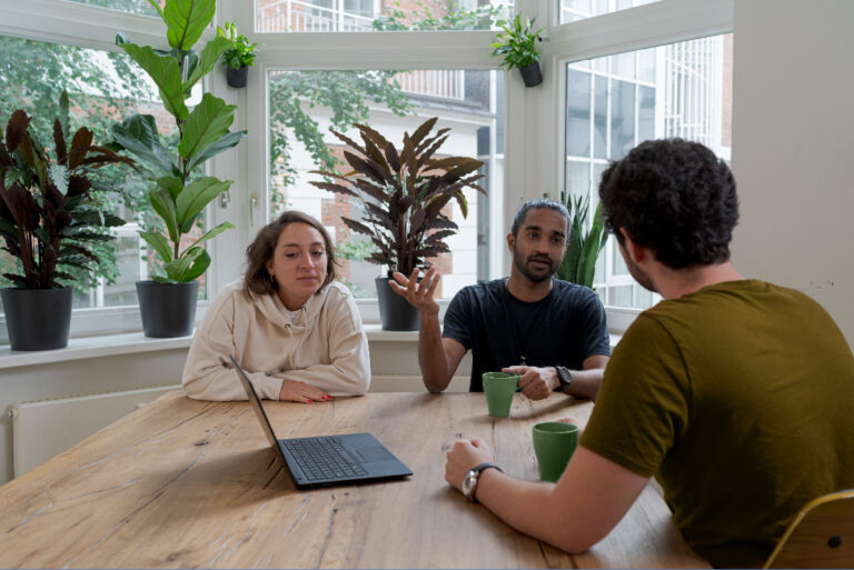 Three people having a conversation at a table